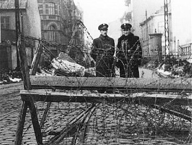 Jewish police at a barricaded entrance to the Warsaw ghetto. Poland, February 1941